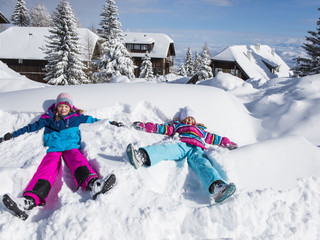 Kinder beim Spielen im Schnee im Winterurlaub mit der Familie in Kärnten