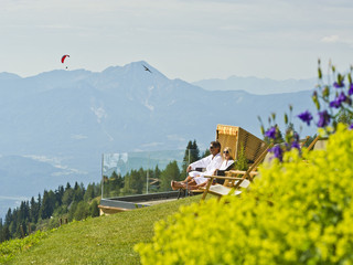 Paar genießt den Ausblick ins Tal vom Berghotel Feuerberg im Sommerurlaub in Kärnten
