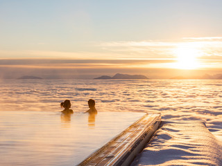 Paar beim Sonnenaufgang im Unendlichpool