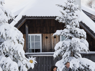 Paar wandert durch das verschneite Chaletdorf im Winter- und Skiurlaub auf der Gerlitzen Alpe in Kärnten