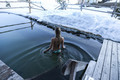 Frau kühlt sich nach der Sauna im Winter im Almsee im Wellnesshotel Feuerberg in Kärnten