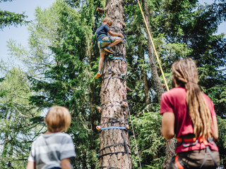 Kinder beim Klettern im Wald im Familienurlaub in den Bergen im Mountain Resort Feuerberg