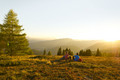 Mann und Frau rasten auf einer Wiese im Sonnenuntergang nach dem Wandern im Wanderurlaub in Kärnten